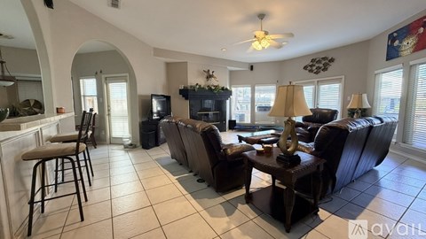 A living room with a black leather couch and a wooden coffee table.