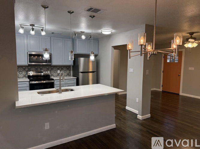 A modern kitchen with a large island and stainless steel appliances.