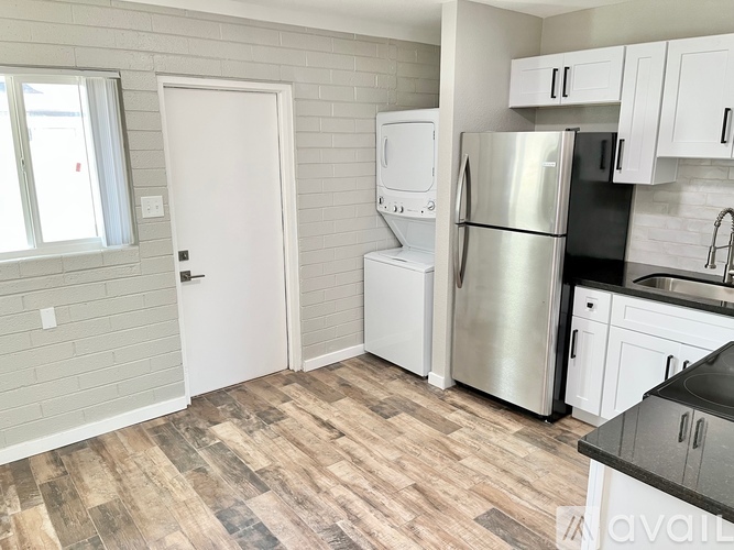 A kitchen with a refrigerator, sink, and cabinets.