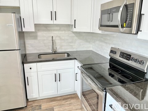 A kitchen with a stove top oven and a refrigerator.