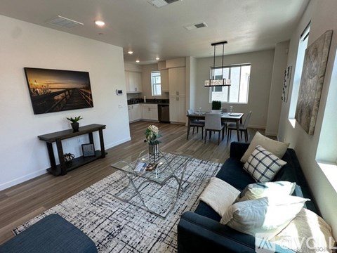 A living room with a couch, coffee table, and a painting on the wall.