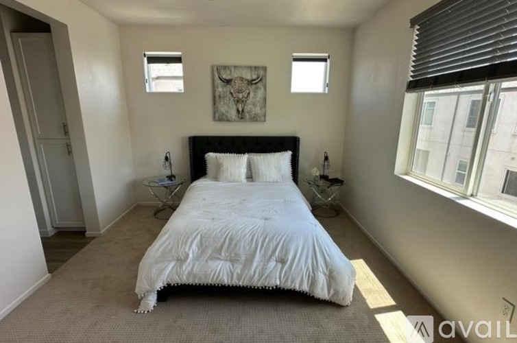 A bedroom with a large bed and a painting on the wall.