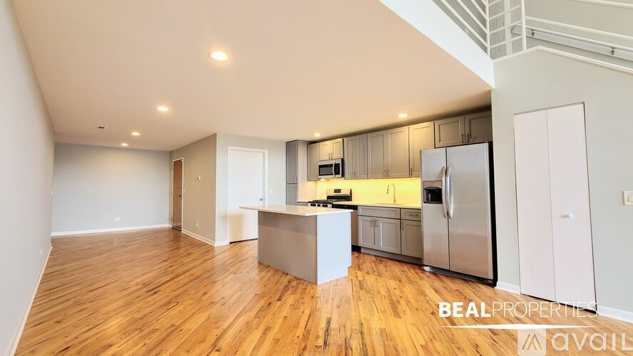 A spacious kitchen with wooden floors and modern appliances.