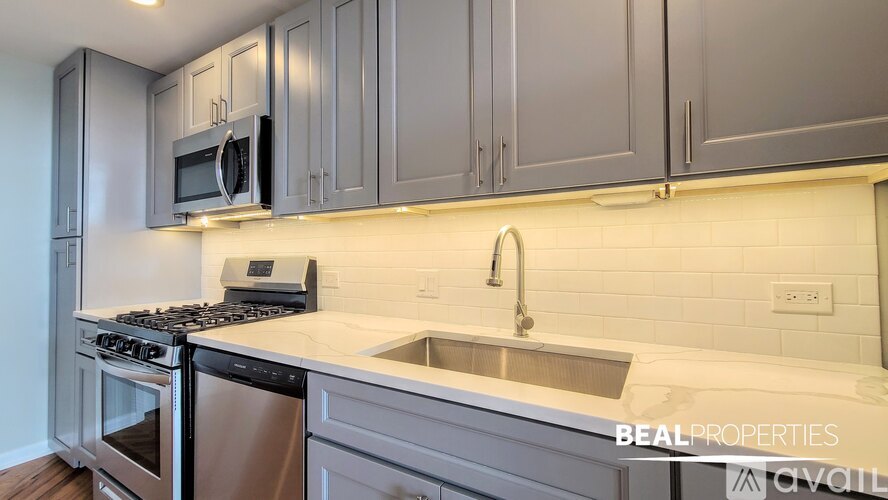 A modern kitchen with a stainless steel dishwasher and a microwave above the stove.
