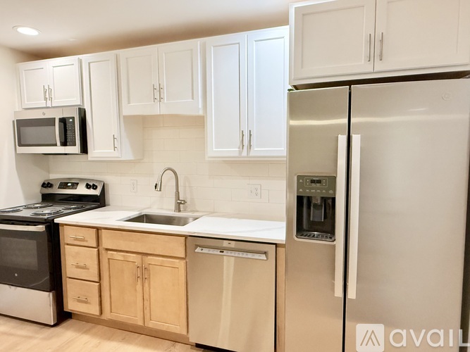 A kitchen with white appliances and wooden cabinets.