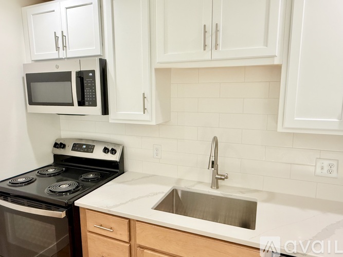A kitchen with a black stove top oven and a black microwave.