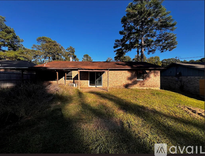 A house with a brown roof and a tree in the background.