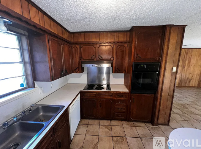 A kitchen with wooden cabinets and a stainless steel sink.