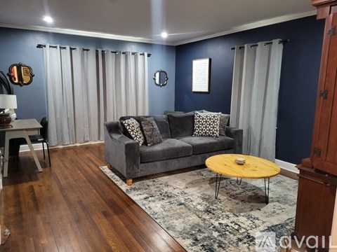 A living room with a grey couch and a yellow coffee table.