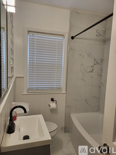 A bathroom with a marble wall and a white sink.