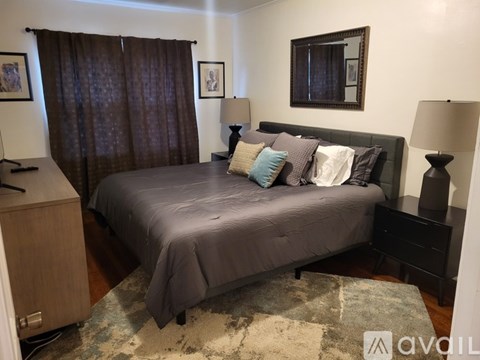 A bedroom with a bed, nightstand, and a rug.
