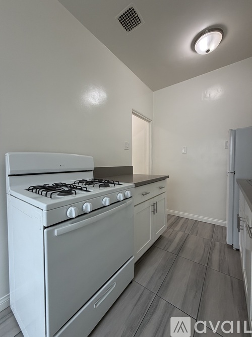 A white gas stove in a kitchen with a grey floor.