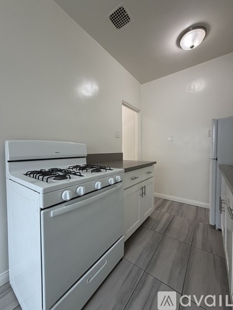 A white gas stove in a kitchen with a grey floor.