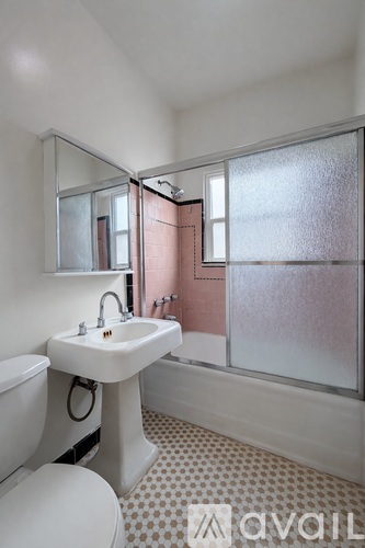 A bathroom with a toilet, sink, and shower.