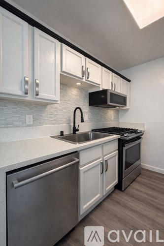A kitchen with white cabinets and a black stove top oven.