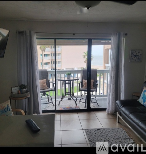 A living room with a sliding glass door leading to a balcony.