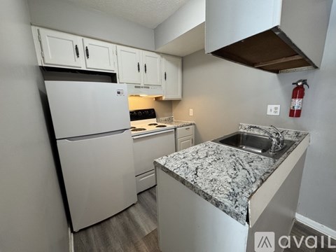 A kitchen with granite countertops and white appliances.