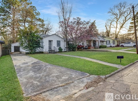 A house with a driveway and a yard with a mailbox.