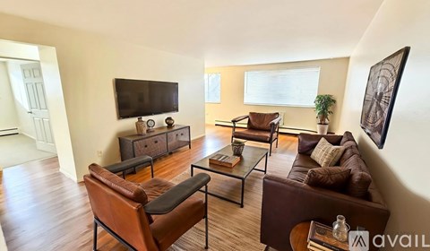 A living room with brown leather furniture and a flat screen TV mounted on the wall.