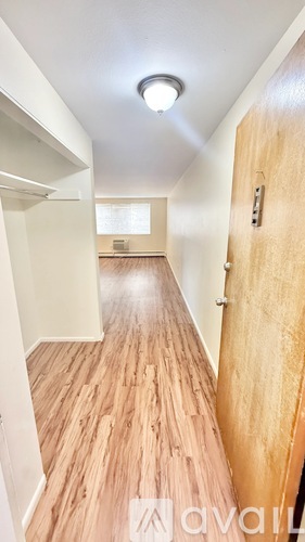 A hallway with wooden floors and white walls.