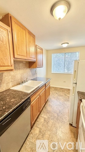 A kitchen with wooden cabinets and a white refrigerator.