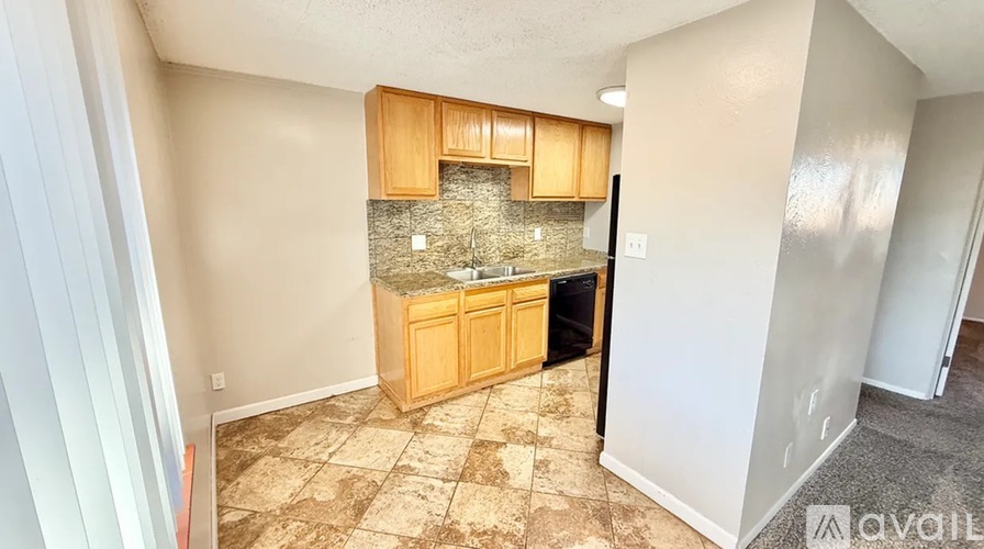 A kitchen area with wooden cabinets and a granite countertop.