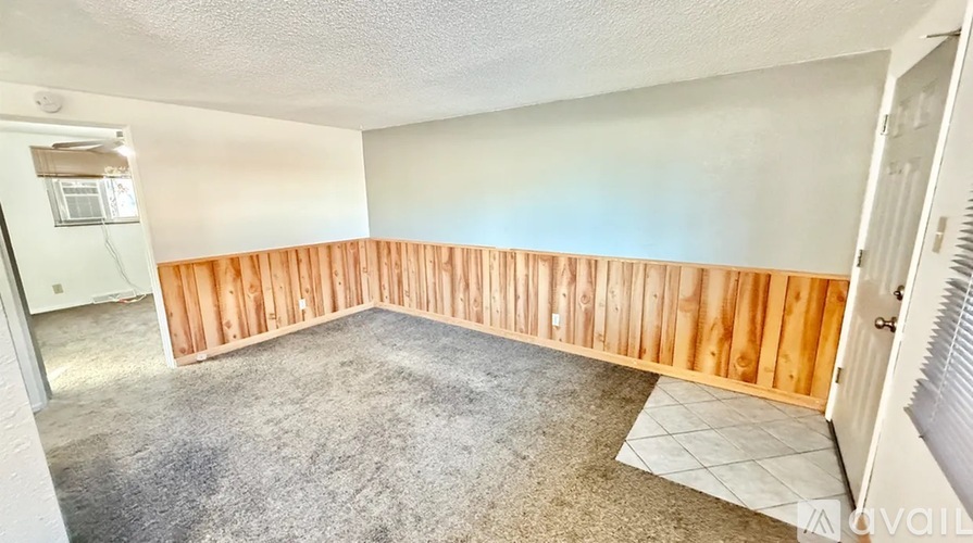 A room with a wooden partition wall and carpeted floor.