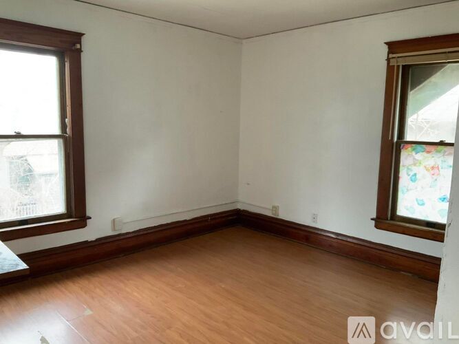 A room with wooden floors and two windows.