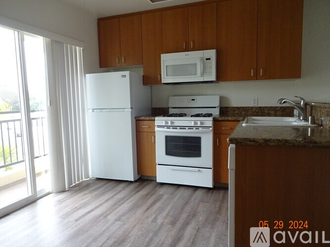 A kitchen with a white fridge, white stove, and brown cabinets.