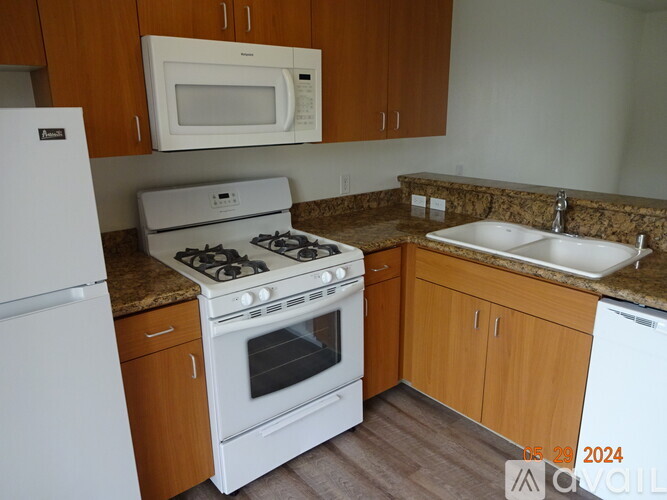 A kitchen with a white stove, oven, and microwave.