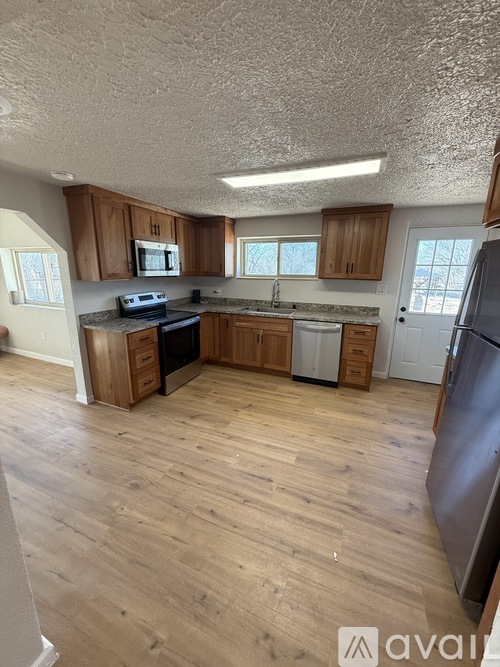 A kitchen with wooden cabinets and a refrigerator.