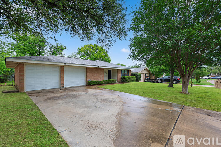A house with a lawn and trees in front of it.
