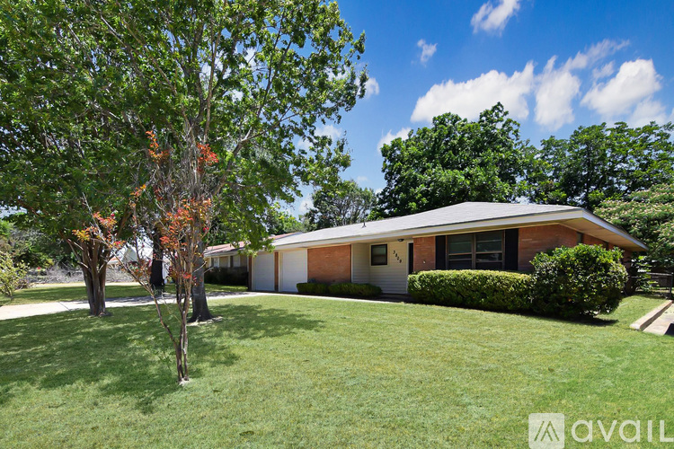 A house with a white garage door is surrounded by trees.