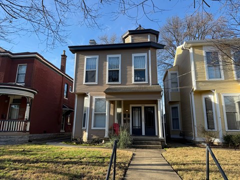 A row of houses with a red one on the left.