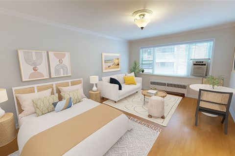 A bedroom with a large bed, a couch, a chair, and a window.