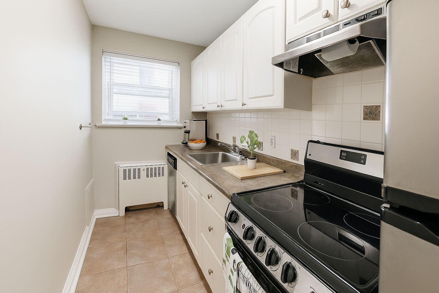 A kitchen with a stove top oven and a window.