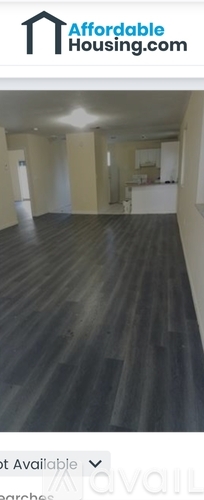 A room with wooden flooring and white walls is available for rent.