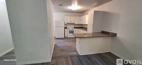 A kitchen with white cabinets and a wooden countertop.