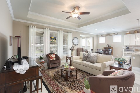 A living room with a brown chair and a white couch.