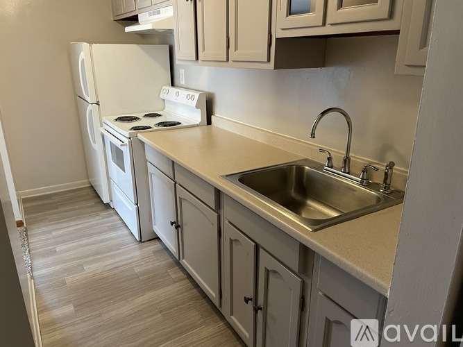 A kitchen with a white fridge, stove, and cabinets.