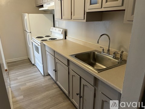 A kitchen with a white fridge, stove, and cabinets.