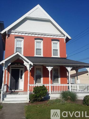 A red and white house with a porch and a front door.