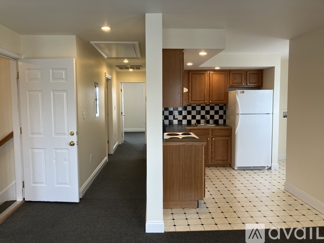 A kitchen with a checkered floor and a white refrigerator.