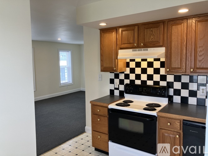 A kitchen with wooden cabinets and a black and white checkered backsplash.