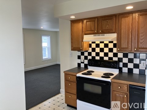A kitchen with wooden cabinets and a black and white checkered backsplash.