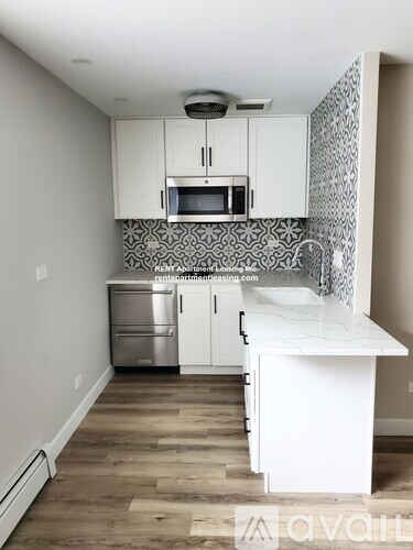 A kitchen with white cabinets and a white island.