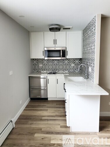 A kitchen with white cabinets and a white island.