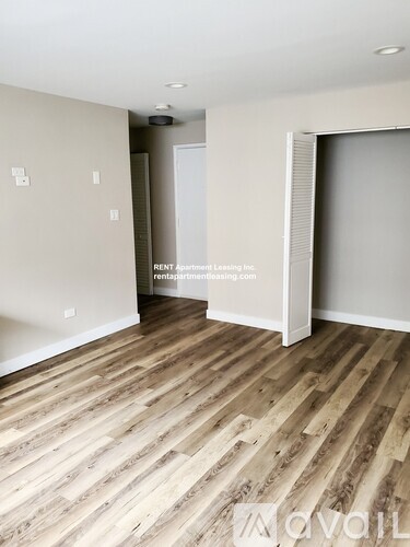 A room with wooden flooring and a white door.