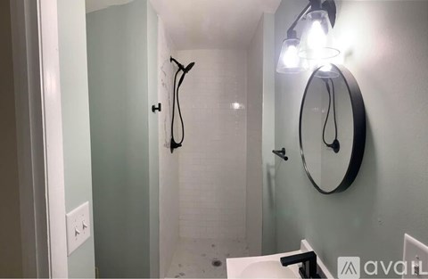A bathroom with a mirror and lights on the wall.