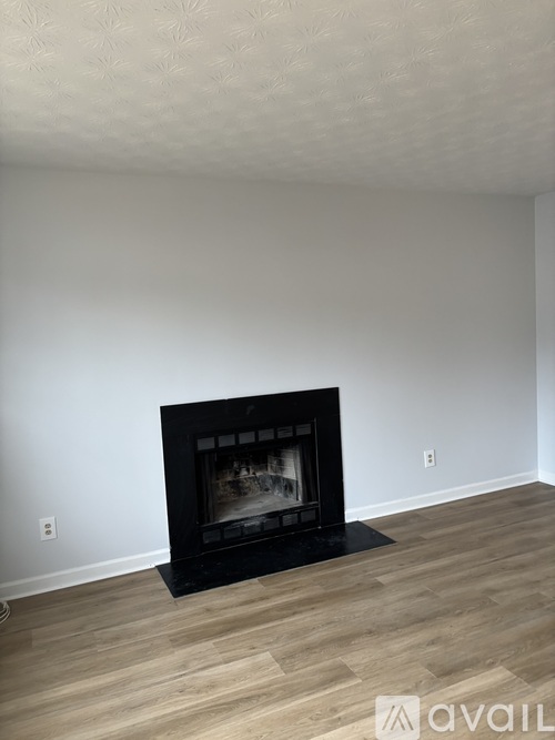 A modern living room with a fireplace and wooden flooring.